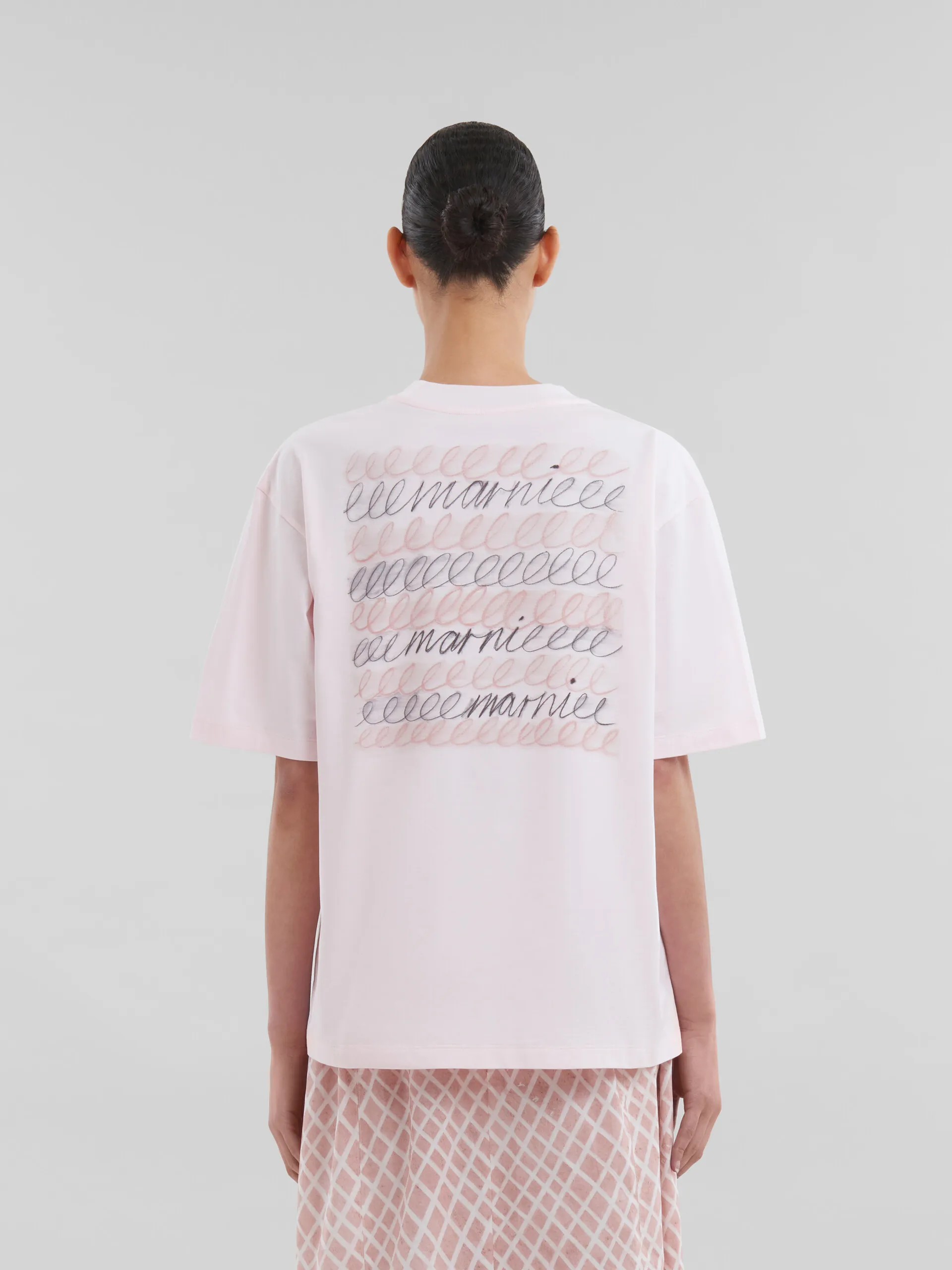 T-shirt linea boxy in cotone biologico rosa con logo ripetuto